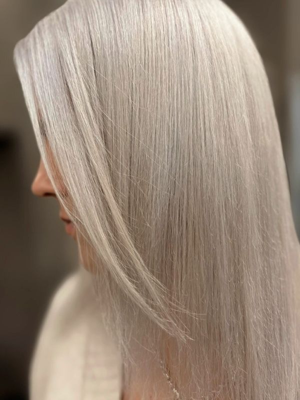 Pitkät, kerrostetut Platinum Blonde -hiukset muotoiltu Niki Newd® Hair Studiossa – moniulotteinen sävy, jossa kaunista liikettä, kirkkautta ja silkkinen pinta.